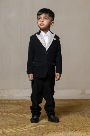 Classic black blazer with a champagne metallic-textured lapel, paired with matching pants and a crisp white shirt for a sophisticated formal look